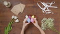 Top view of a table with items to create a composition for Easter. Women& x27;s hands knock eggs against each other and Royalty Free Stock Photo