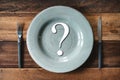 Top view of a table set of cutlery with symbol of question mark in a plate