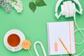 Top view of the table of a teenage child, composition headphones notebook pencil flower drink Lollipop eraser on light green Royalty Free Stock Photo