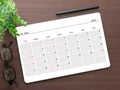 Top view, tablet digital pc showing May 2023 calendar app on brown wooden table. Royalty Free Stock Photo