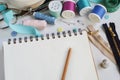 Top view tailor accessories and tools. Blank notepad surrounded with cutting scissors, spools of thread, violet fabric. Copy space Royalty Free Stock Photo