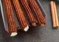 Top view of take away coffee next to chocolate filled and plain churros Royalty Free Stock Photo