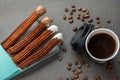 Top view of take away coffee next to chocolate filled and plain churros Royalty Free Stock Photo