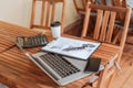 Top view.takeaway coffee, financial chart, and laptop on coffee table.