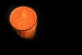 top view on tall plastic glass of fresh orange carrot juice