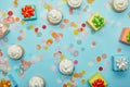 Top view of tasty cupcakes, confetti and gifts