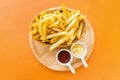 Top view Tasty French fries or potato fry  with salt served in a wooden basket with tomato ketchup and mayonnaise on wooden tray . Royalty Free Stock Photo