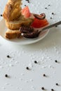 Top view of tasty Italian appetizers -  bruschetta with raw tomatoes and octopus tentacles, on slices of toasted baguette Royalty Free Stock Photo