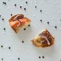 Top view of tasty Italian appetizers -  bruschetta with raw tomatoes and octopus tentacles, on slices of toasted baguette Royalty Free Stock Photo