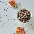 Top view of tasty Italian appetizers -  bruschetta with raw tomatoes and octopus tentacles, on slices of toasted baguette Royalty Free Stock Photo