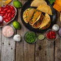 Top view of tasty mexican tacos with meat on black round plate on rustic wooden table. Traditional mexican cuisine. Healthy Royalty Free Stock Photo