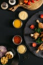 top view of tasty roasted chicken wings with various sauces and vegetables Royalty Free Stock Photo