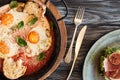 top view of tasty roasted eggs, fork with knife and prosciutto