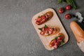 top view of tasty tomato bruschetta on wooden board and fresh ingredients on grey Royalty Free Stock Photo