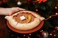 Top view on tasty traditional Adjarian Khachapuri - open baked pie with meat and pepperyolk on wooden tray. Traditional georgian