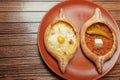 Top view on tasty traditional Adjarian Khachapuri - open baked pie with melted salt cheese suluguni and egg and