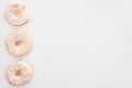 Top view of tasty whole doughnuts with sprinkles near bitten one on white background.