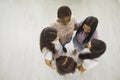 Top view of a team of happy young women standing in a circle and hugging each other