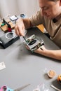 Top view of technician male working on electronic device, holding computer hardware with exposed cooling fan, performing Royalty Free Stock Photo