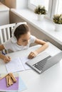 Top view of a teenager girl doing homework at home in front of a laptop monitor Royalty Free Stock Photo