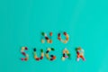 Top view of text made of colorful bean sweet candies on turquoise blue background. Healthy food and diet concept. Copy