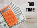 Top view text TAX TIME with calculator and fake money