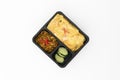 Top view of thai food, spicy curry pork with cucumber and friend egg in black contain box isolate in white