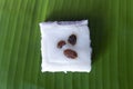 Top view of Thai sweet sticky rice cake with coconut milk and currant topping on banana leaf. Royalty Free Stock Photo