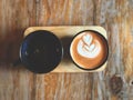 Top view.Thai tea latte art and hot drink in Black cup on wooden tray Royalty Free Stock Photo