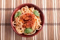 Top view of a thin spaghetti in a brown small wooden bowl