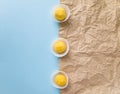 Top view of three chocolate truffles in white candy wrappers on a blue and beige background. Royalty Free Stock Photo