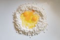 Top view of three eggs in a pile of flour on kitchen counter