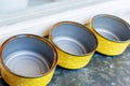 Top view of three empty, old tin cans with yellow exteriors and rusted rims Royalty Free Stock Photo
