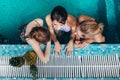 Top view of three female swimmers sitting in a swimming pool resting after training and gossiping Royalty Free Stock Photo