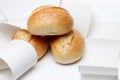 Top view of three german wheat buns in a bunch of empty receipts on white isolated background, receipt obligation in germany also Royalty Free Stock Photo