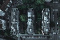 Top view of three identical apartment buildings with trees and cars on the street