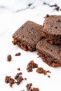 Top view of three pieces of chocolate brownie with crumbs, on white marble table, in vertical, Royalty Free Stock Photo