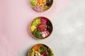 Top view of three plates full of diet dishes on a grey and pink background- vegan food concept Royalty Free Stock Photo