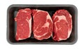 Top view of three ribeye steaks in a black foam retail meat tray isolated on a white background