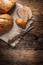 Top view of three slices of crisp baked bread on a vintage cloth and wooden background with a knife on the side Royalty Free Stock Photo