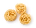 Top view of three uncooked tagliatelle pasta nests