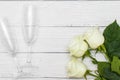 Top view of three White roses and two champagne glasses on old white wooden table love concept Royalty Free Stock Photo