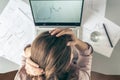 Top view. Tired business woman with headache at office with glass of water and pill on the background of graphics and charts print