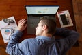 Top view of tired exhausted businessman sleeping on laptop keyboard at workplace. Handsome overworked freelancer man Royalty Free Stock Photo