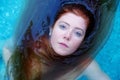 Top view to a beautiful young sexy erotic seductive redhead woman portrait lying in the water of the spa wellness pool, lightly Royalty Free Stock Photo