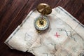 Top view to fake Pirates Vintage map of Treasure Island with red cross on wooden table Royalty Free Stock Photo