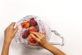 Top view to kis hands putting peaches in mesh glocery shopping bag on white background Royalty Free Stock Photo