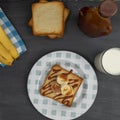 top view of a toasted bread with banana and cajeta and a glass of milk