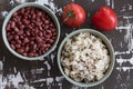 Top view of tomato, cooked beans and mixed brown and black rice as ingredients for salad on the wooden background Royalty Free Stock Photo