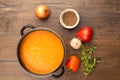 Top view of tomato puree soup in a pan and vegetables on a wooden background Royalty Free Stock Photo